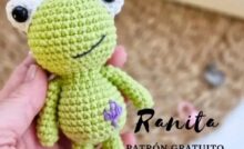 Rana de ganchillo con sombrero verde y ojos verdes, destacando su diseño artesanal y colorido.